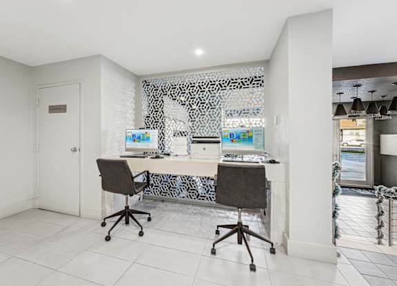 A white room with a desk and chairs.