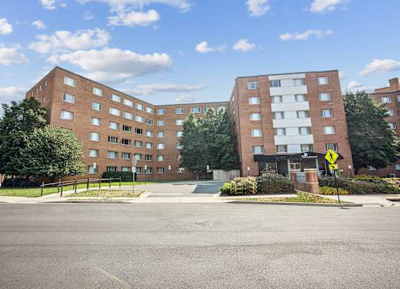 A street view of a residential area with two apartment buildings at Wellington Apartments, Arlington, Virginia