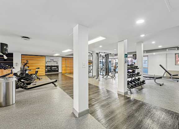 A gym with a variety of equipment including treadmills, weights, and exercise machines at Wellington Apartments, Arlington, Virginia