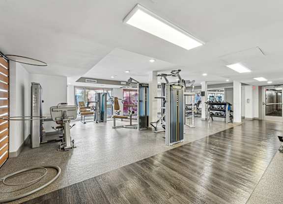 A gym with a variety of equipment including treadmills, weights, and exercise machines at Wellington Apartments, Arlington, Virginia