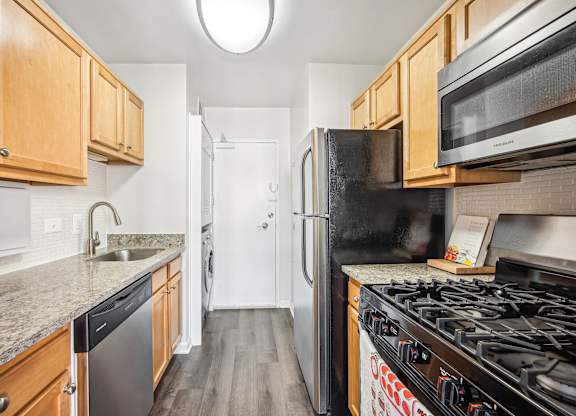 A kitchen with a black refrigerator and a black stove top oven at Wellington Apartments, Arlington, Virginia