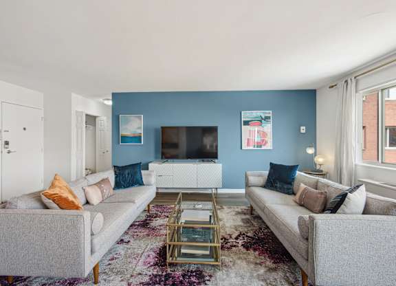 A living room with a grey couch, a coffee table, and a flat screen TV.