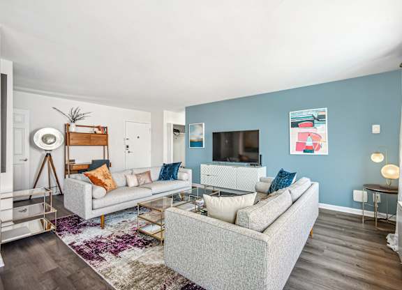 A living room with a grey couch and a white coffee table at Wellington Apartments, Arlington, Virginia