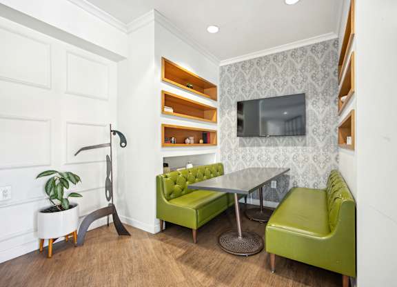 A living room with a green couch and a television at Wellington Apartments, Arlington, Virginia