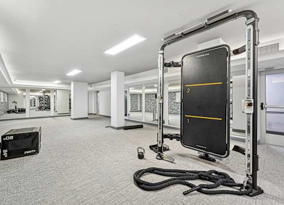 A gym with a rope, a bench, and a black screen with a yellow line.