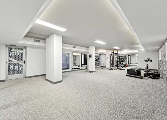 A spacious gym with a variety of equipment and a white color scheme at Wellington Apartments, Arlington, Virginia