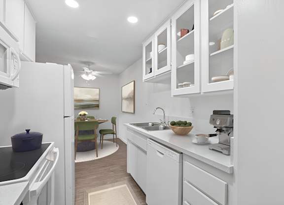 Kitchen 1005 Via Zapata apartment home with wood-style plank flooring, white cabinetry, white appliances and dining nook with overhead ceiling fan.