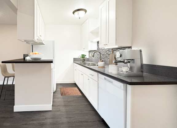 A modern kitchen with white cabinets and a black countertop.