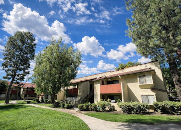 A row of houses with trees in front.