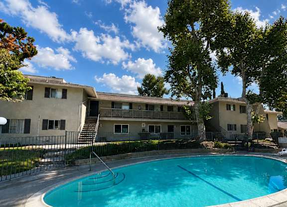 luxurious swimming pool in interior courtyard of 955 Via Zapata surrounded by large trees.
