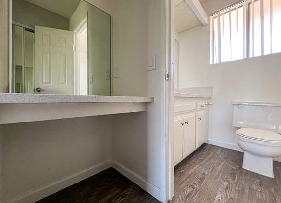 Bathroom in 955 Via Zapata apartment home with wood-style plank flooring, vanity station enclosed room with additional sink vanity, toilet and a shower/tub