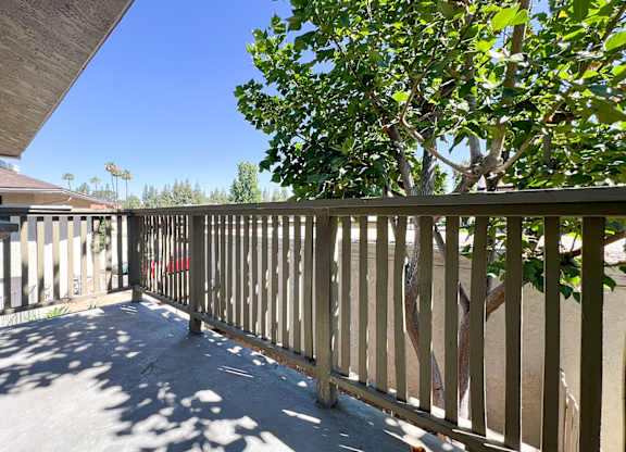 Charming private balcony in 955 Via Zapata apartment home with wood railings, and large shade trees surrounding for gorgeous views and a tree-house feel