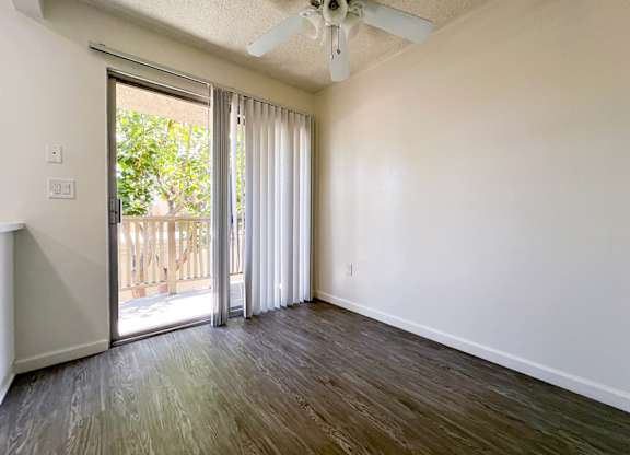 Dining Nook in 955 Via Zapata apartment home with wood-style plank flooring, an overhead ceiling fan, and sliding doors leading to a private balcony.