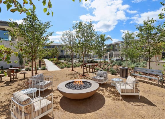 an outdoor patio with a fire pit and benches at The Max on Jefferson Apartments, Murrieta, 92562