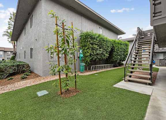A house with a green lawn and a tree in front of it.