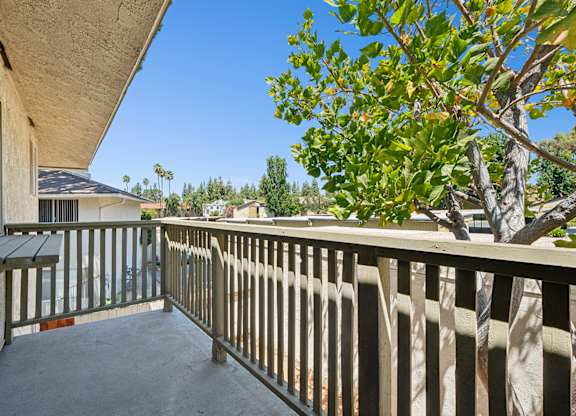 Charming private balcony in 955 Via Zapata apartment home with wood railings, and large shade trees surrounding for gorgeous views and a tree-house feel