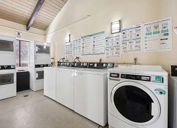 A laundromat with a row of washers and dryers.