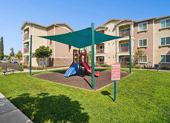 Play park at Turtle Creek under shade sail surrounded by park-like landscaping