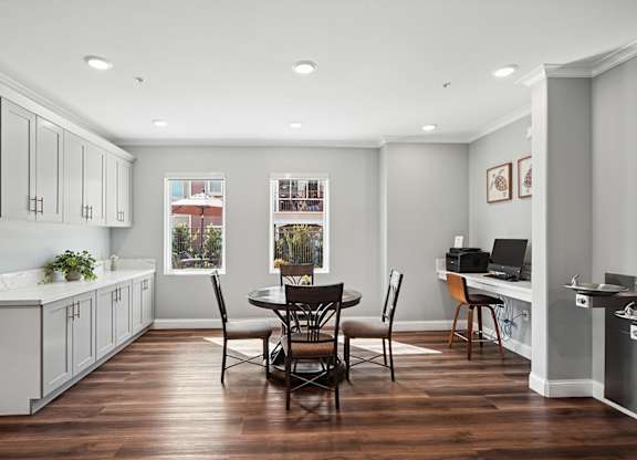 Dining area in Turtle Creek community clubhouse with seating, plus computer desk for business center, and kitchenette.