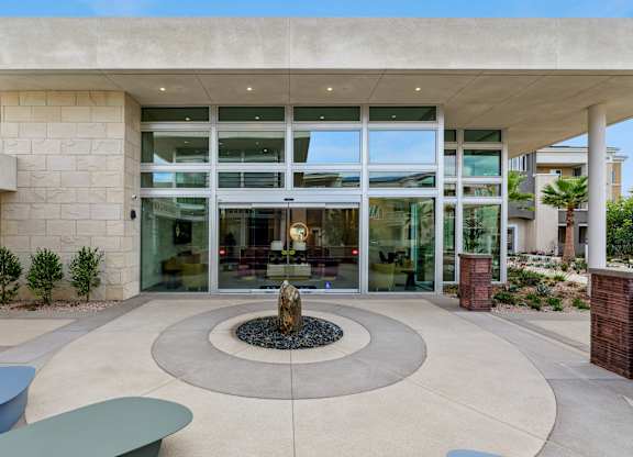 Serene rock fountain sculpture and seating area by the Leasing Office & Community Clubhouse at The Park.