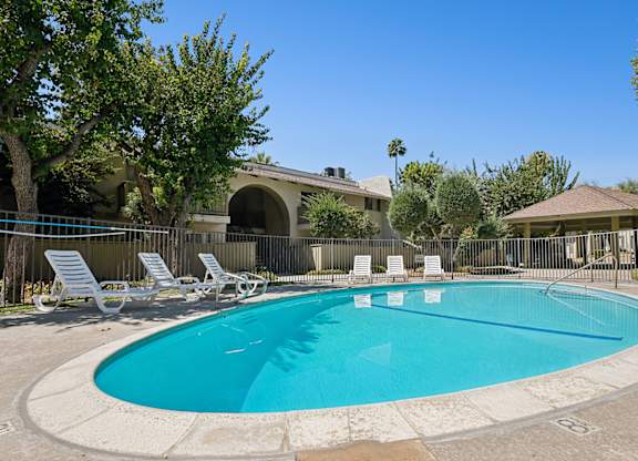 luxurious swimming pool in interior courtyard of 955 Via Zapata surrounded by large trees.
