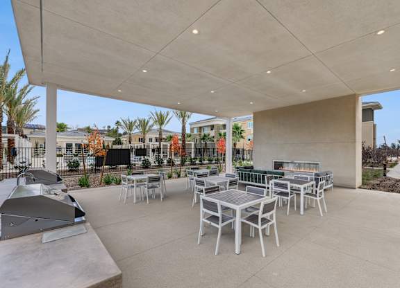 Outdoor barbecue area outside the pool yard at The Park with plenty of dining tables and fireside lounge seating.