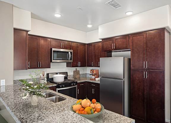 A kitchen with a refrigerator, microwave, and stove.