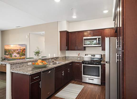 A kitchen with brown cabinets and a granite countertop.