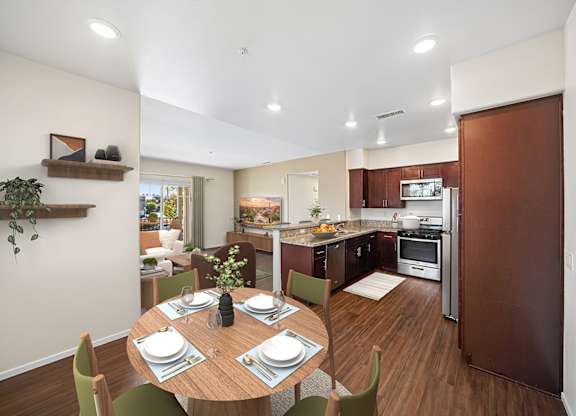 A modern kitchen with a dining table set for two.