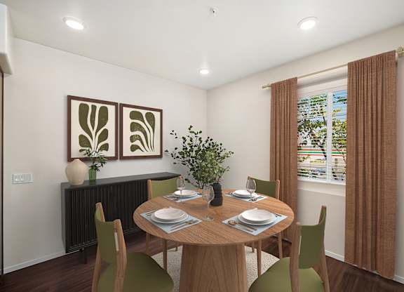 A dining room with a table set for two and a potted plant on the table.