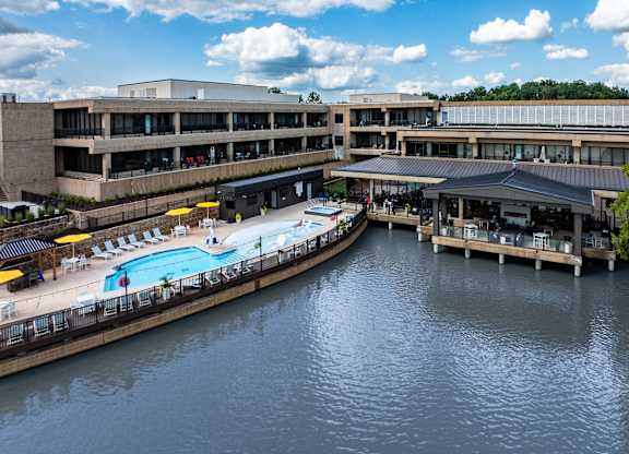 A large building with a pool in front of it.