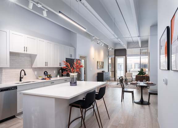 A modern kitchen with white cabinets and a large island.