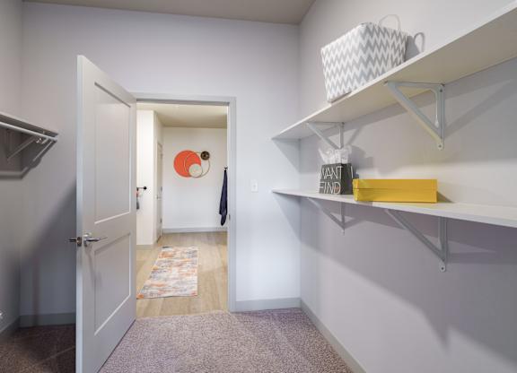 A hallway with a white door and a yellow box on a shelf.