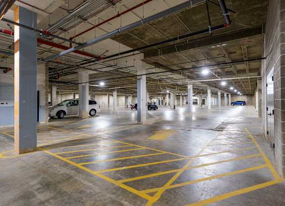 A parking garage with yellow lines on the floor.