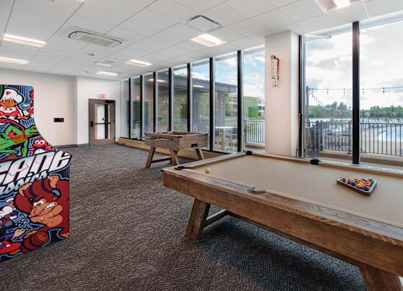 A billiard table in a room with a pool table poster on the wall.