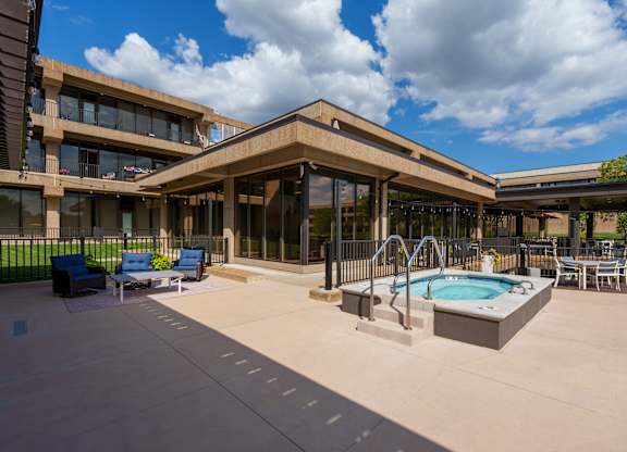 A large outdoor swimming pool area with a building in the background.