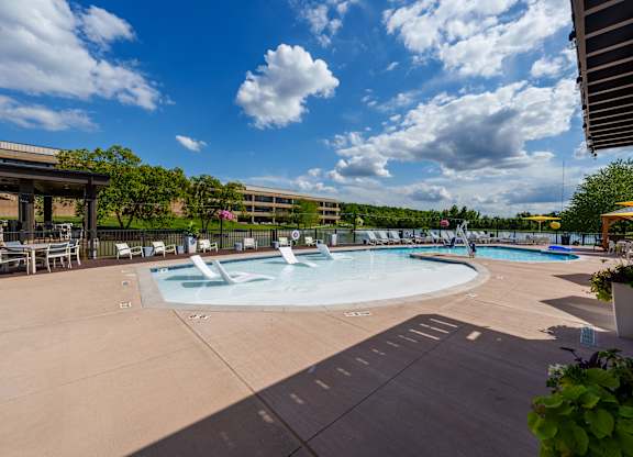 A large outdoor swimming pool with a fountain in the middle.
