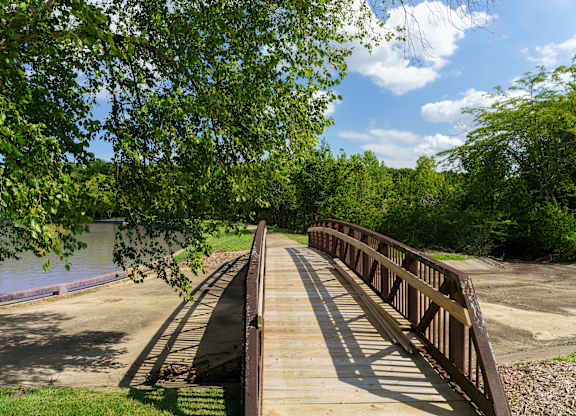 A bridge over a river with trees on the left.