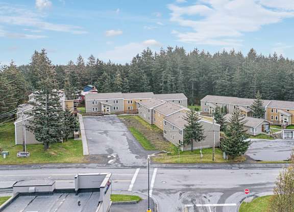 A large building complex with a parking lot in front.