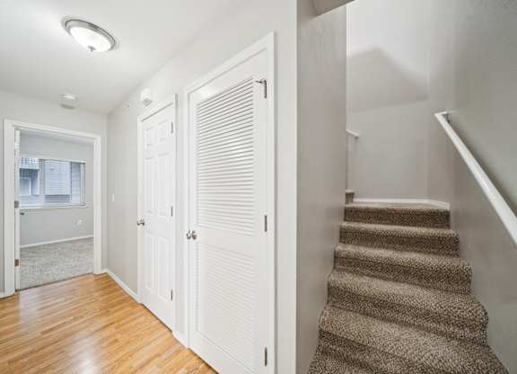 A hallway with a staircase and a window.