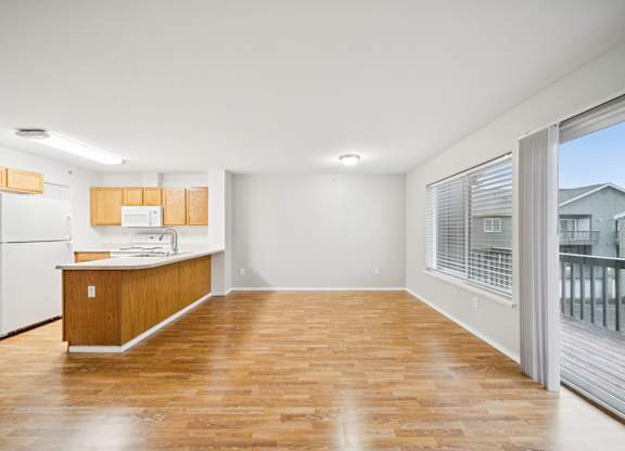 A kitchen with wooden floors and white appliances.