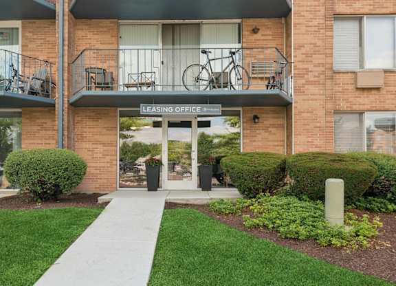 A brick building with a leasing office sign on the door.
