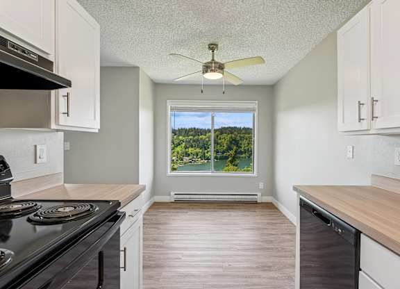 A kitchen with a black stove top oven and white cabinets.