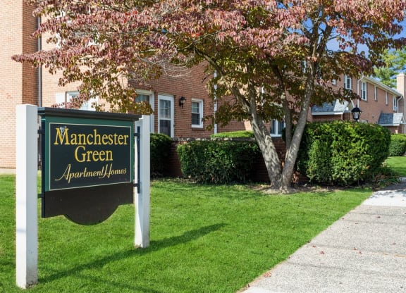 Front lawn sign with apartment logo for Manchester Green