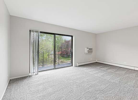 A room with a carpeted floor and a sliding glass door.