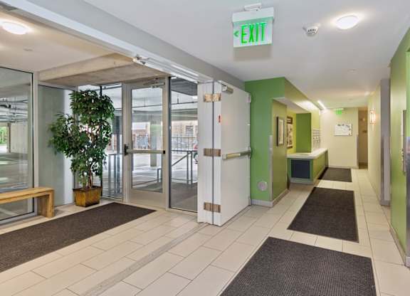 A hallway with a green exit sign at the top.