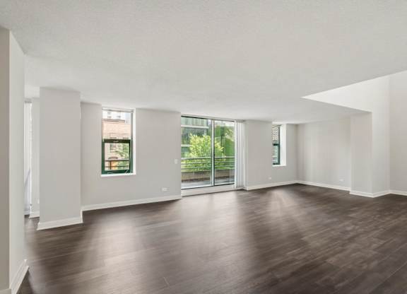 A large empty room with wooden floors and white walls.
