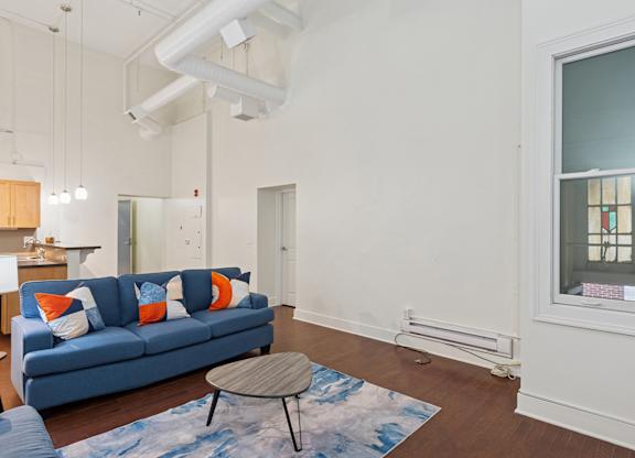 A living room with a blue couch and a small table.