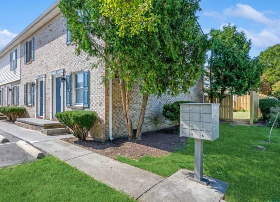 a brick building with blue shutters and a mailbox in front of it at Fort Collier Terrace, Virginia, 22601
