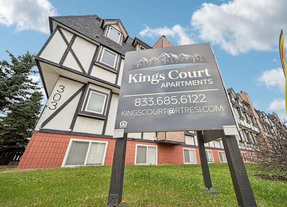 A sign for Kings Court Apartments stands in front of a building.